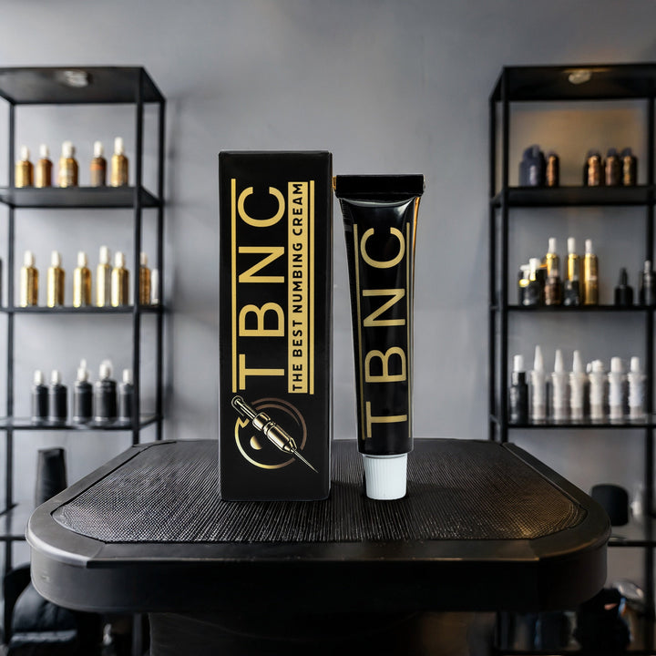 TBNC numbing cream packaging on a black surface with shelves in the background