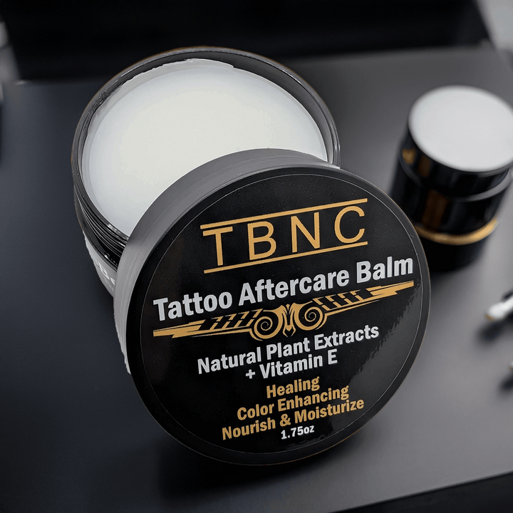 TBNC Tattoo Aftercare Balm jar on a dark surface