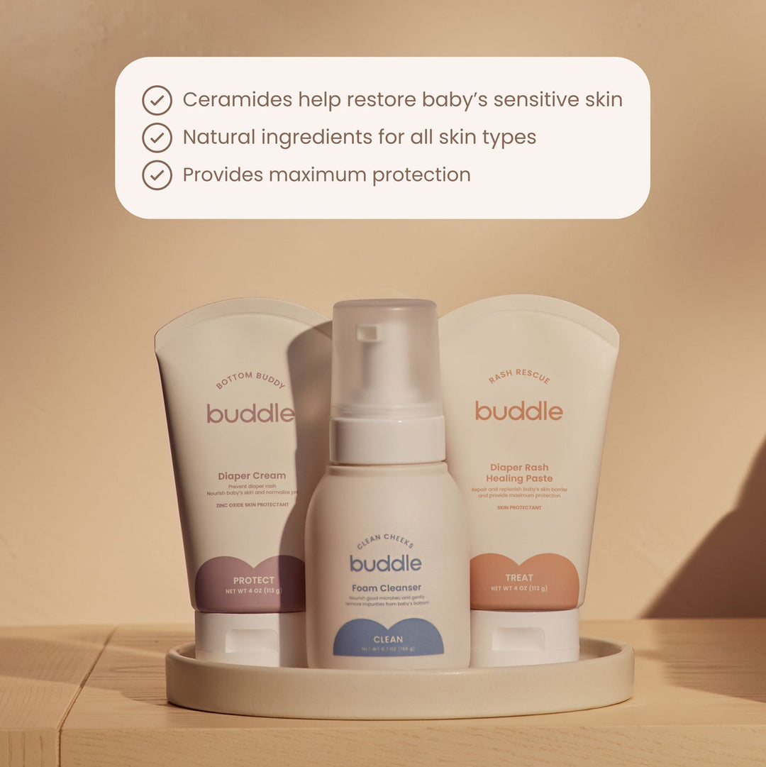 Buddle baby skincare products on a wooden surface with a beige background