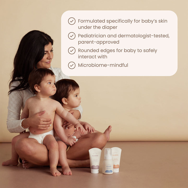 Woman holding two babies with baby care products and text about product features on a beige background