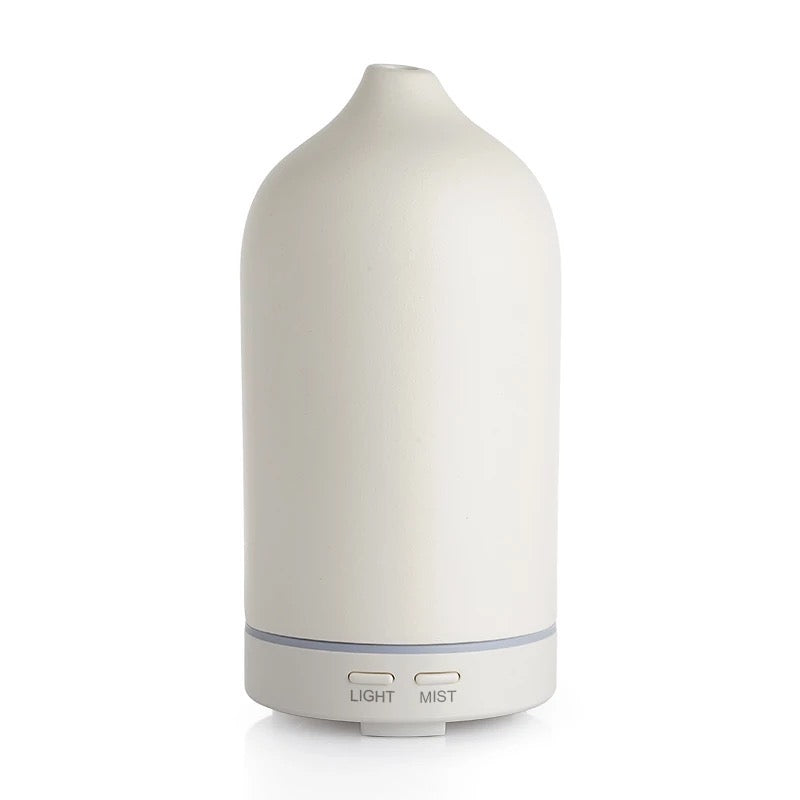 White essential oil diffuser with light and mist buttons on a white background