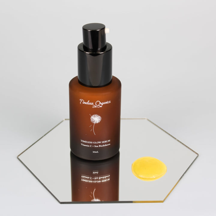 Timeless Organic face serum in a brown bottle with black cap on a reflective surface