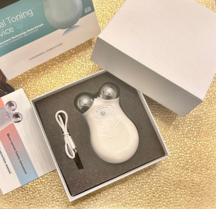 White electronic device with cable in an open box on a gold textured surface