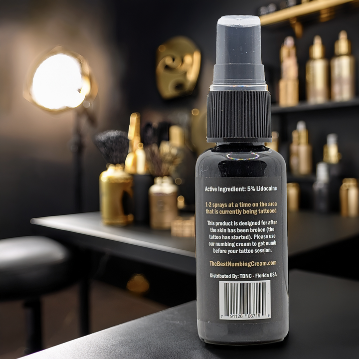 Tattoo numbing spray bottle, showing back of label on spa background. 