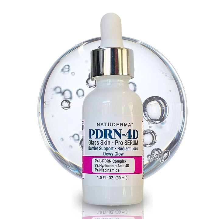 A bottle of Natuderma PDRN-4D Glass Skin Pro Serum, featuring a white dropper cap, silver collar, and a pink and blue label, set against a clear glass bubble background on a white studio background.