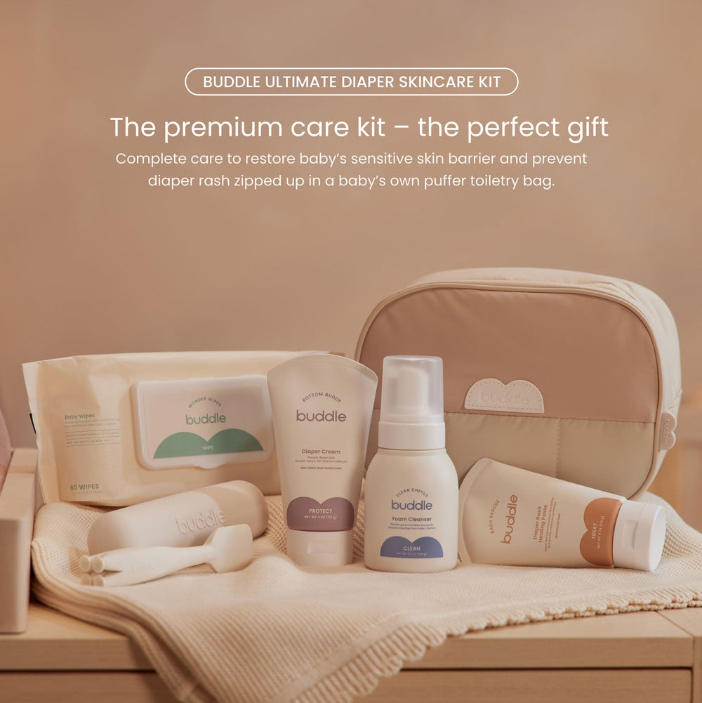 Buddle diaper skincare kit with products and pouch on a wooden surface.