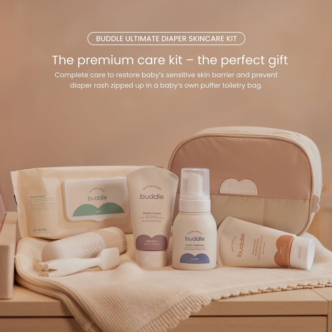 Buddle diaper skincare kit with products and pouch on a wooden surface.