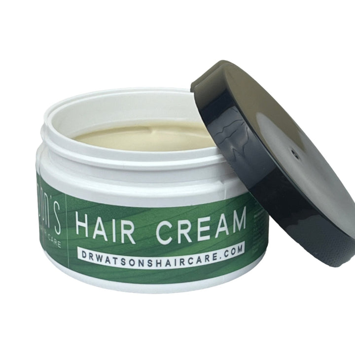 Jar of hair cream with a green label on a white background