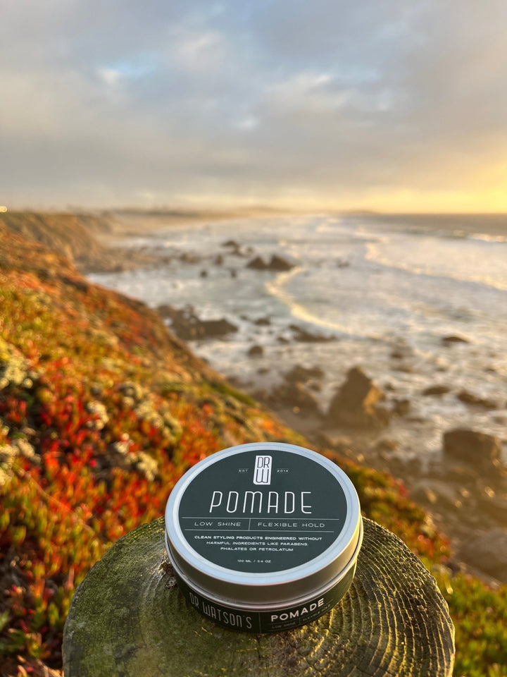 Pomade container with a scenic background of a river and mountains.