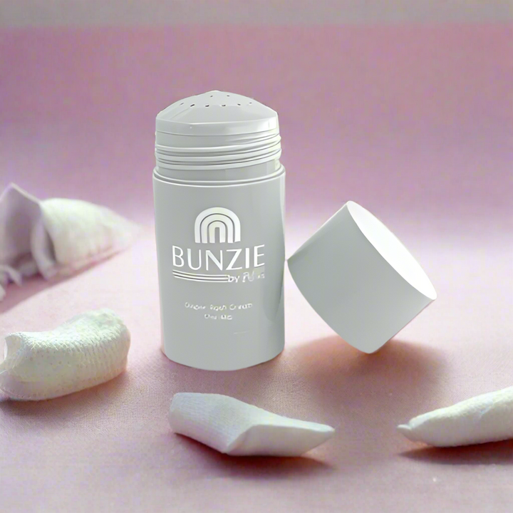 Baby diaper rash cream with white  stick  applicator with packaging on a pink background